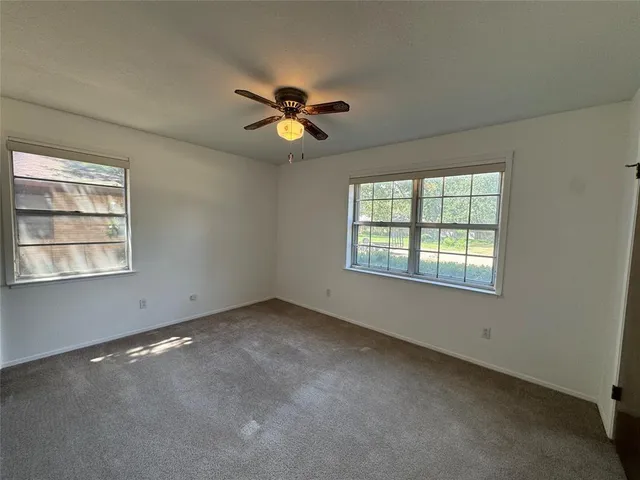 a view of room with a ceiling fan and window