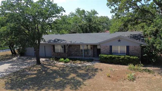 a front view of a house with a yard covered with snow