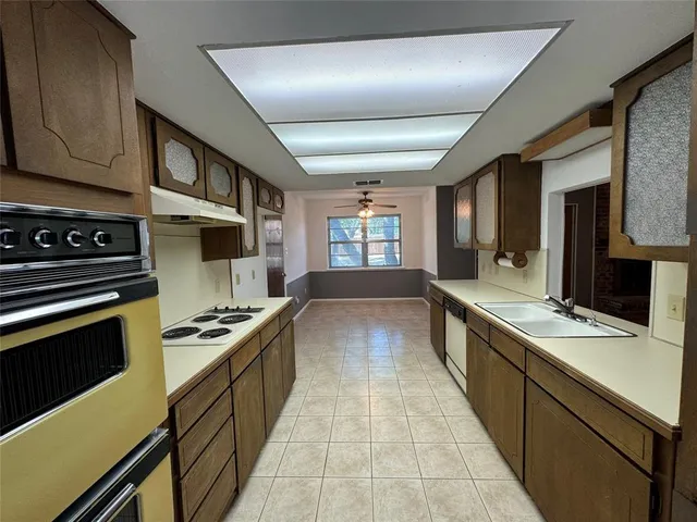 a large kitchen with stainless steel appliances granite countertop a stove and a sink