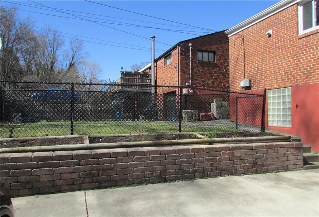 668 Kelso Road Mt. Lebanon, PA 15243 - Photo 22 of 25 View towards fenced-in area of yard, shows gardens ready for planting and nice retaining wall.
