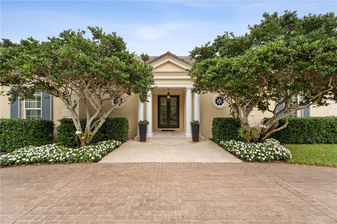 1070 Beach Road, Unit 1070 Vero Beach, FL 32963 - Photo 4 of 36 a front view of a house with a garden and trees