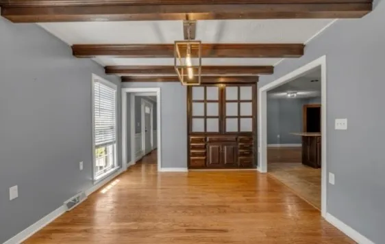 a view of an empty room with a fireplace and a window