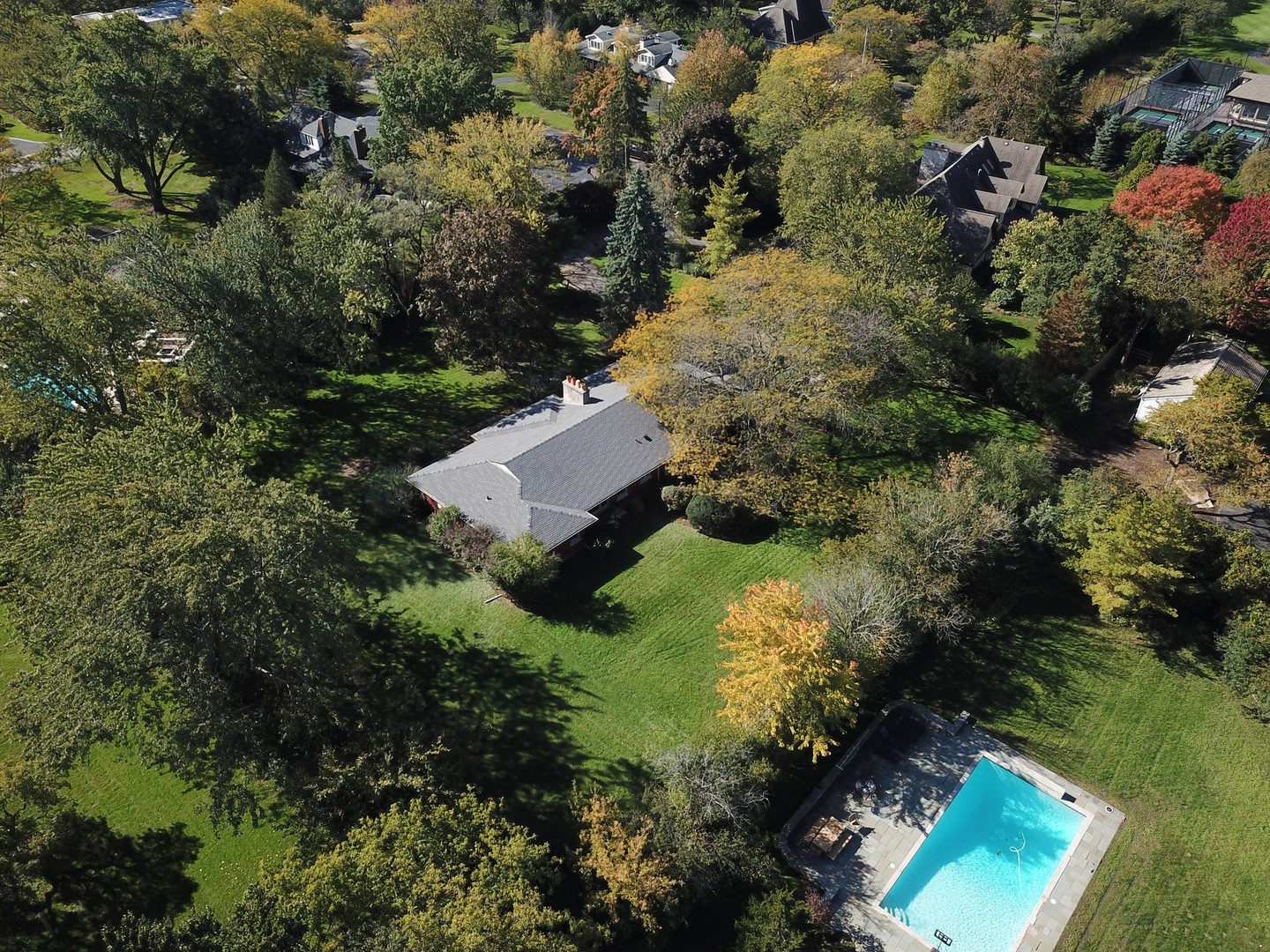 an aerial view of residential house with outdoor space and trees all around