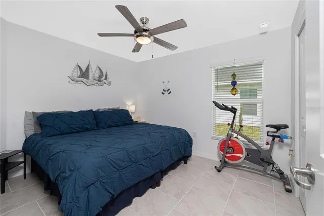 a bedroom with a bed a chandelier and a window