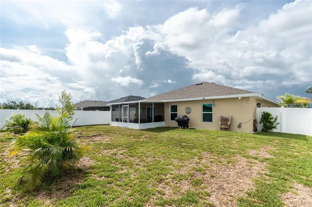 a house that has a big yard with plants and large trees