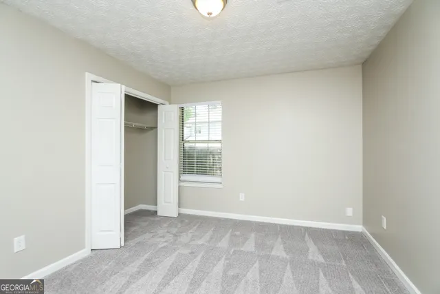 an empty room with windows and closet