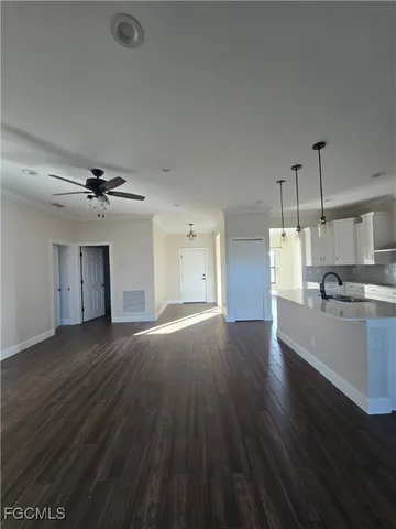 wooden floor in an empty room with a kitchen