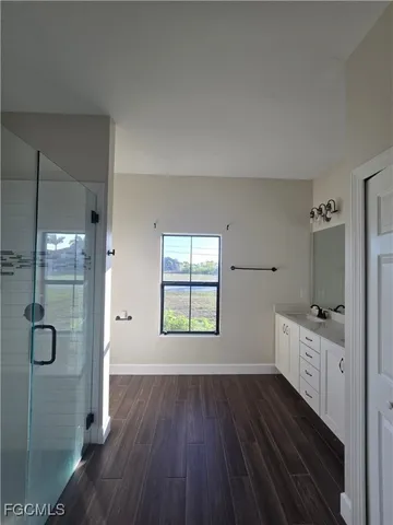 a bathroom with a wooden floor and a window