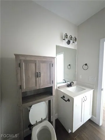 a bathroom with a granite countertop toilet sink and mirror