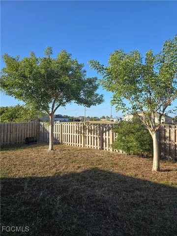 a view of a yard with wooden fence
