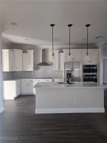 a kitchen with kitchen island a counter top space appliances and cabinets