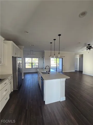 a kitchen with stainless steel appliances wooden floors stove and white cabinets