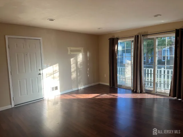 a view of a big room with wooden floor and windows