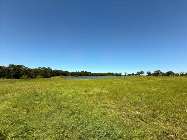 a view of a lake next to a lake with houses in the back