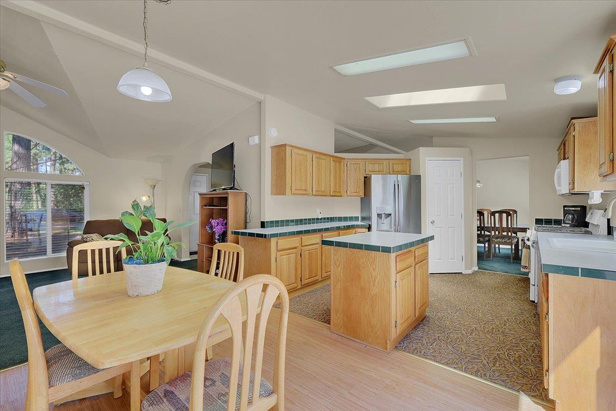 138 Big Fir Road Forbestown, CA 95941 - Photo 21 of 56 a kitchen with stainless steel appliances granite countertop a stove a sink dishwasher a dining table and chairs with wooden floor