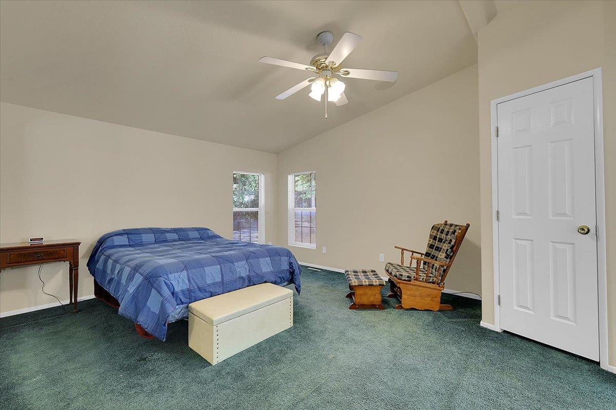 138 Big Fir Road Forbestown, CA 95941 - Photo 29 of 56 a spacious bedroom with a bed and a chandelier