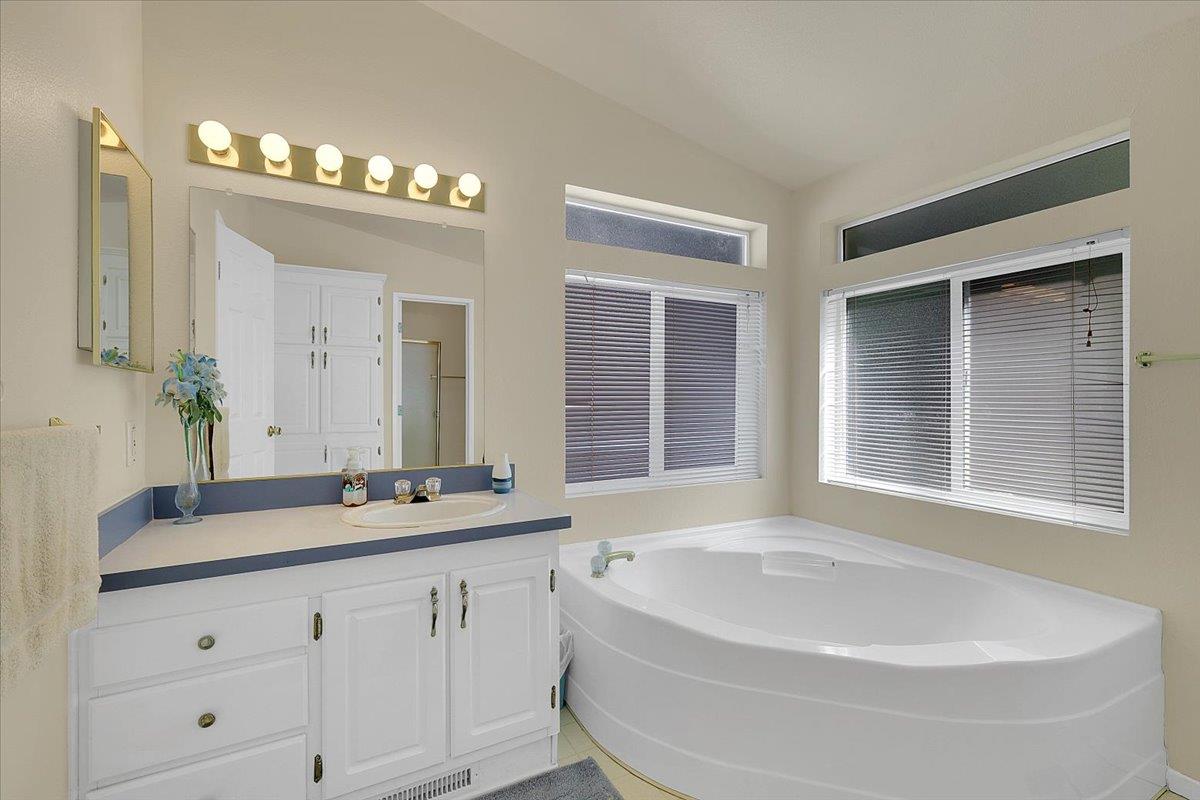 138 Big Fir Road Forbestown, CA 95941 - Photo 33 of 56 a bathroom with a bathtub a double vanity sink a vanity a window and a mirror
