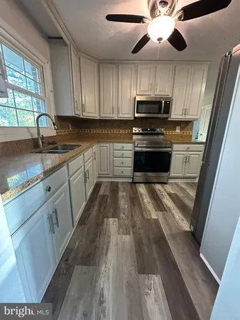a kitchen with wooden floors a sink and appliances