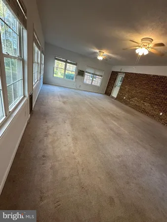 a view of a livingroom with a ceiling fan and window