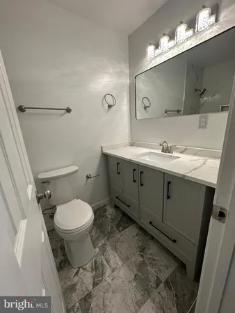 a bathroom with a sink toilet and a mirror