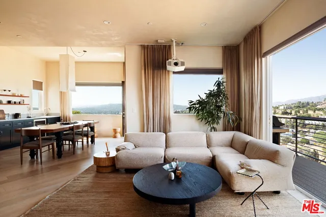a living room with furniture wooden floor and a large window