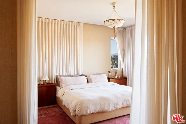 a bedroom with a bed and a chandelier