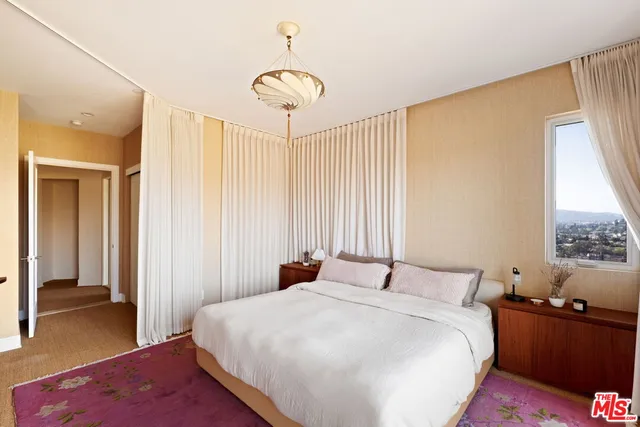 a bedroom with a bed and a dresser with wooden floor