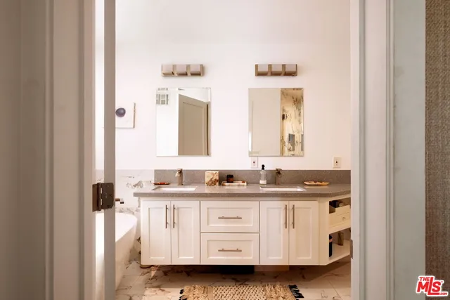 a bathroom with a double vanity sink and mirror