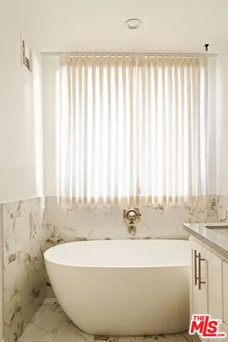 a bath tub sitting in a bathroom next to a window