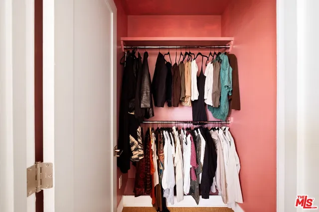 a view of walk in closet with clothes and shoes