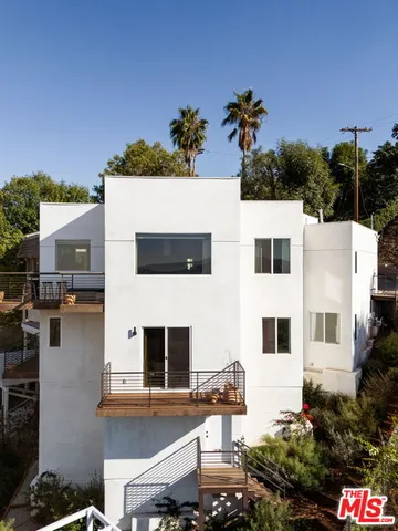 a view of a white house with a yard