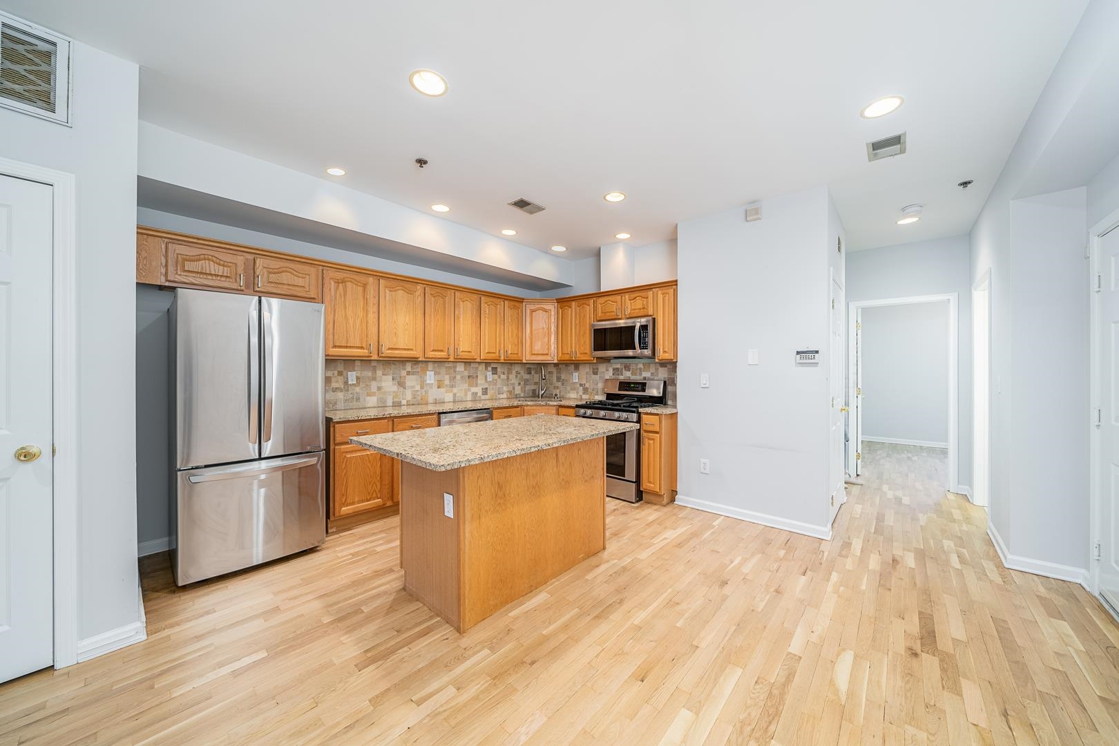 122 Monroe Street, Unit 3 Hoboken, NJ 07030 - Photo 3 of 24 a kitchen with stainless steel appliances granite countertop a refrigerator and a stove top oven