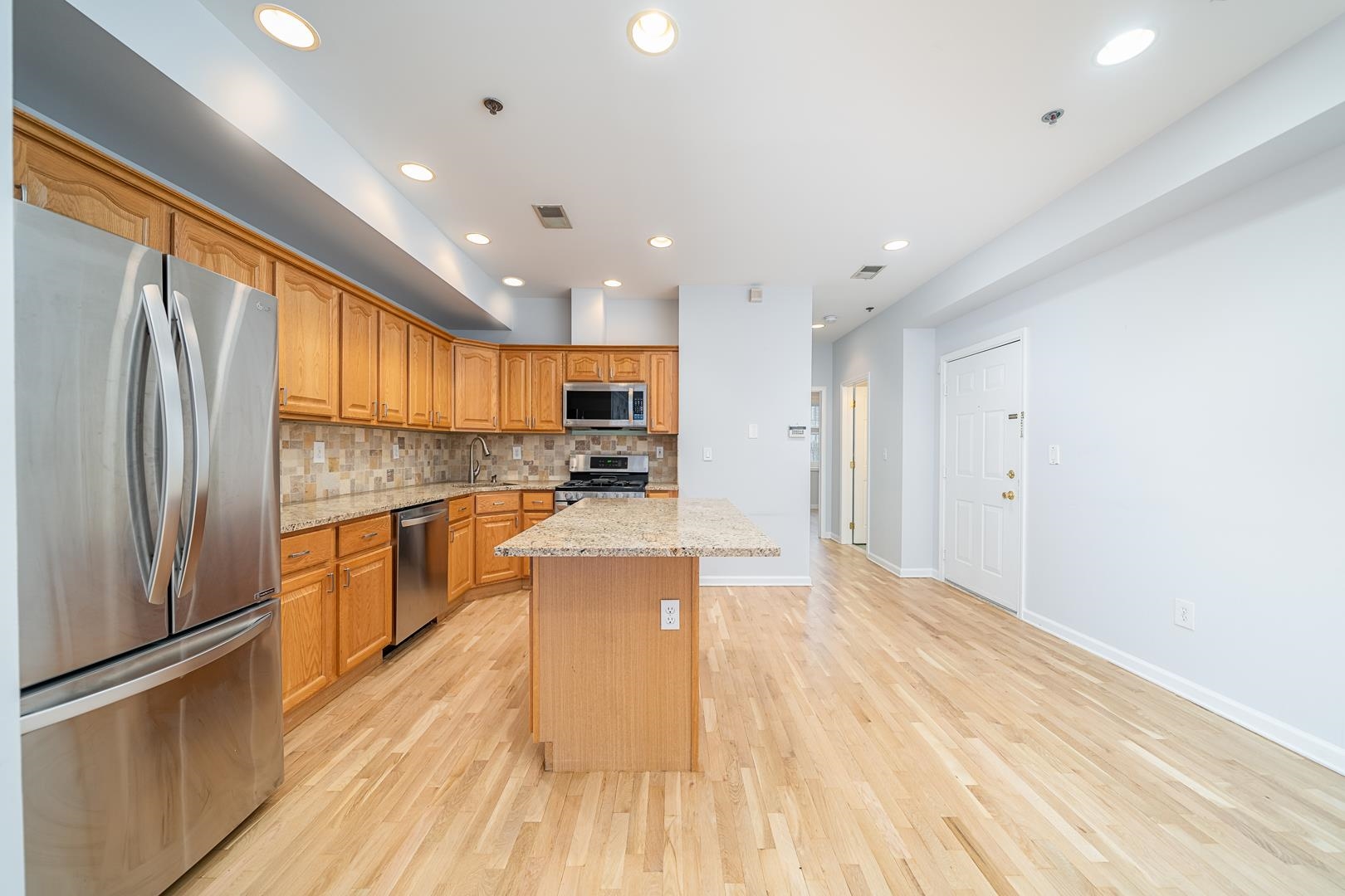 122 Monroe Street, Unit 3 Hoboken, NJ 07030 - Photo 4 of 24 a large kitchen with stainless steel appliances kitchen island a large counter top and a refrigerator