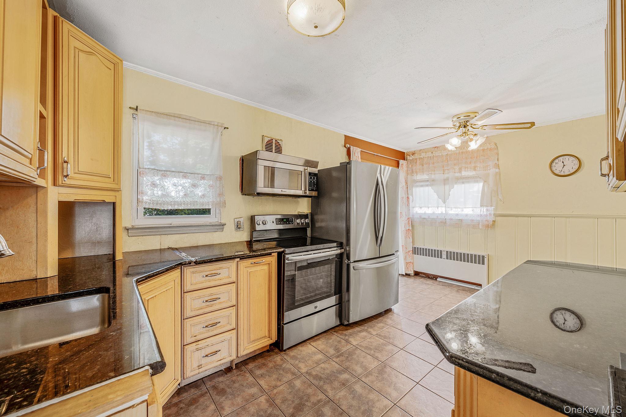2001 North Jerusalem Road East Meadow, NY 11554 - Photo 10 of 31 a kitchen with stainless steel appliances granite countertop a sink and a refrigerator