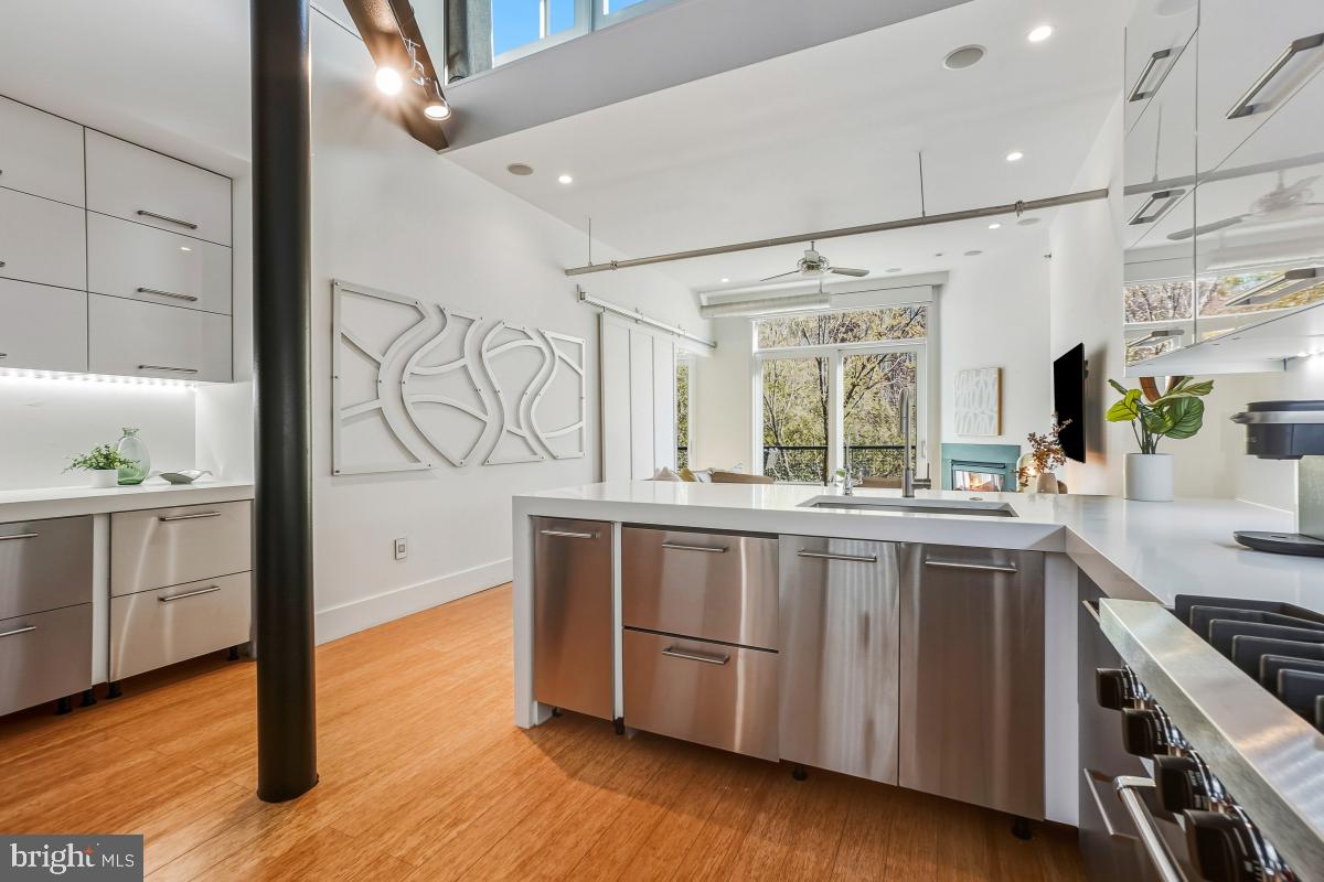 1700 Kalorama Road Northwest, Unit 407 Washington, DC 20009 - Photo 11 of 30 a open kitchen with stainless steel appliances granite countertop a stove and wooden floor
