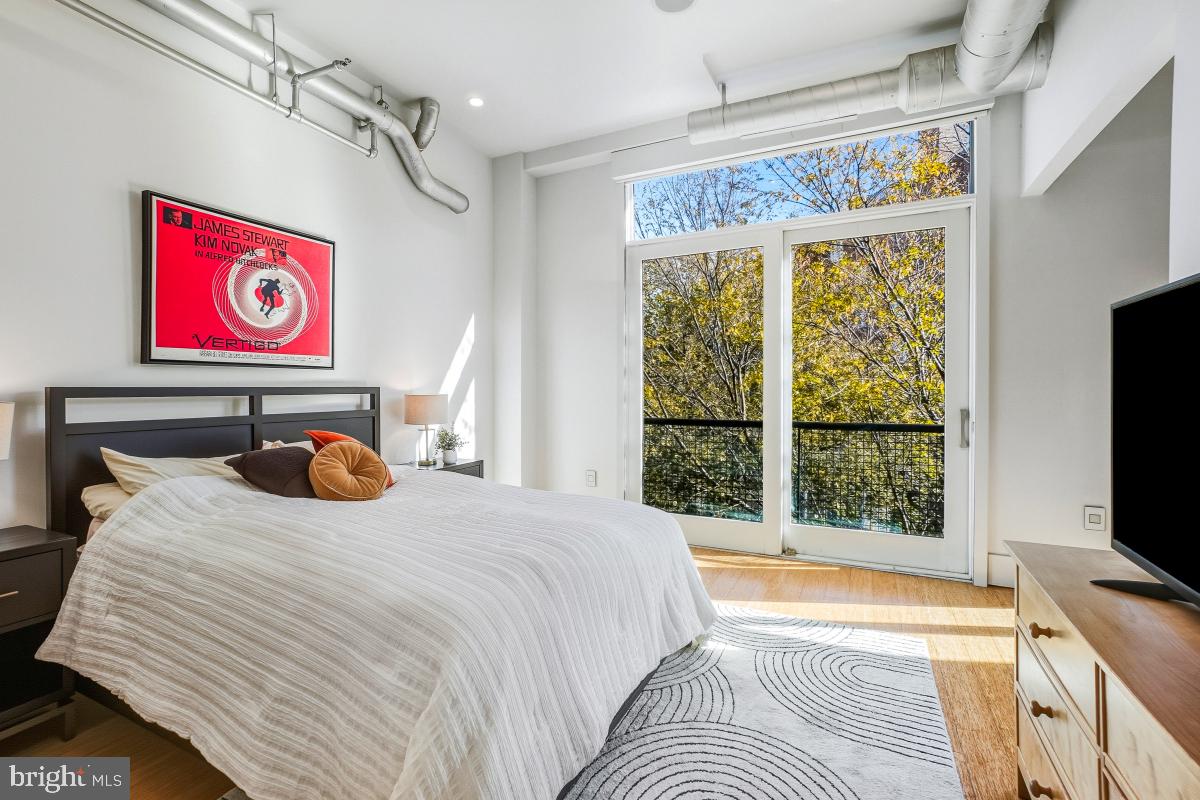 1700 Kalorama Road Northwest, Unit 407 Washington, DC 20009 - Photo 16 of 30 a bedroom with a bed and a flat tv screen on the dresser