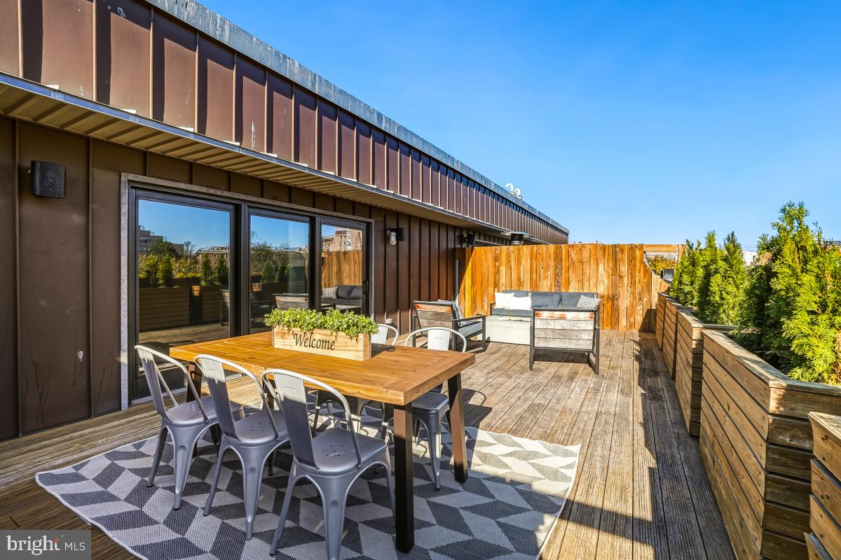 1700 Kalorama Road Northwest, Unit 407 Washington, DC 20009 - Photo 26 of 30 a view of a patio with table and chairs with wooden floor and fence