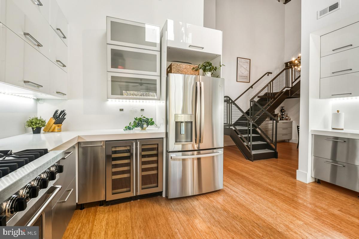 1700 Kalorama Road Northwest, Unit 407 Washington, DC 20009 - Photo 10 of 30 a kitchen with stainless steel appliances a stove and wooden floor