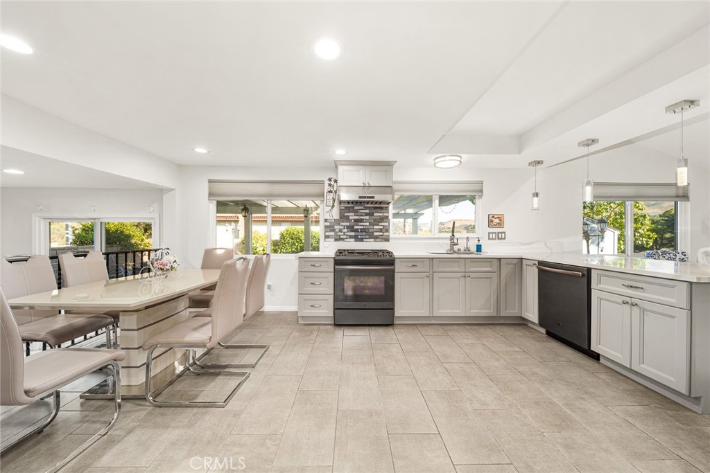 12 Rolling Hills Drive Phillips Ranch, CA 91766 - Photo 15 of 40 a large white kitchen with a stove a sink dishwasher and a refrigerator with wooden floor