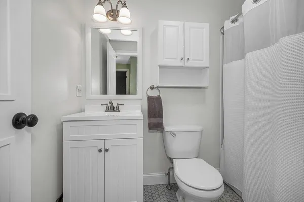 a bathroom with a toilet sink and mirror
