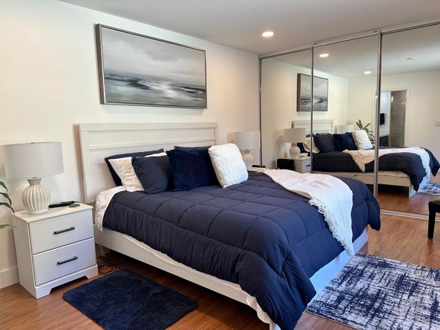 a bedroom with a large bed and a painting on the wall