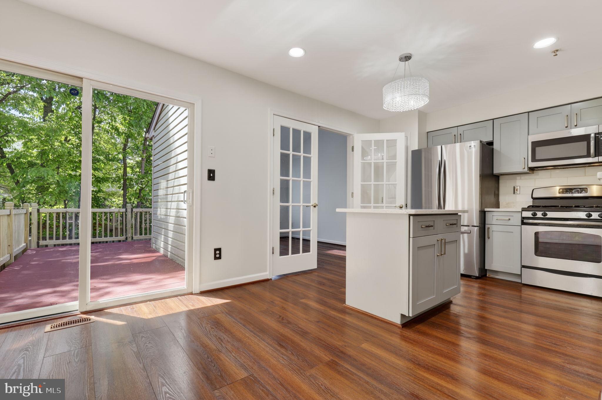 8612 Fire Rock Road Laurel, MD 20724 - Photo 12 of 57 a kitchen with stainless steel appliances a refrigerator and wooden floor