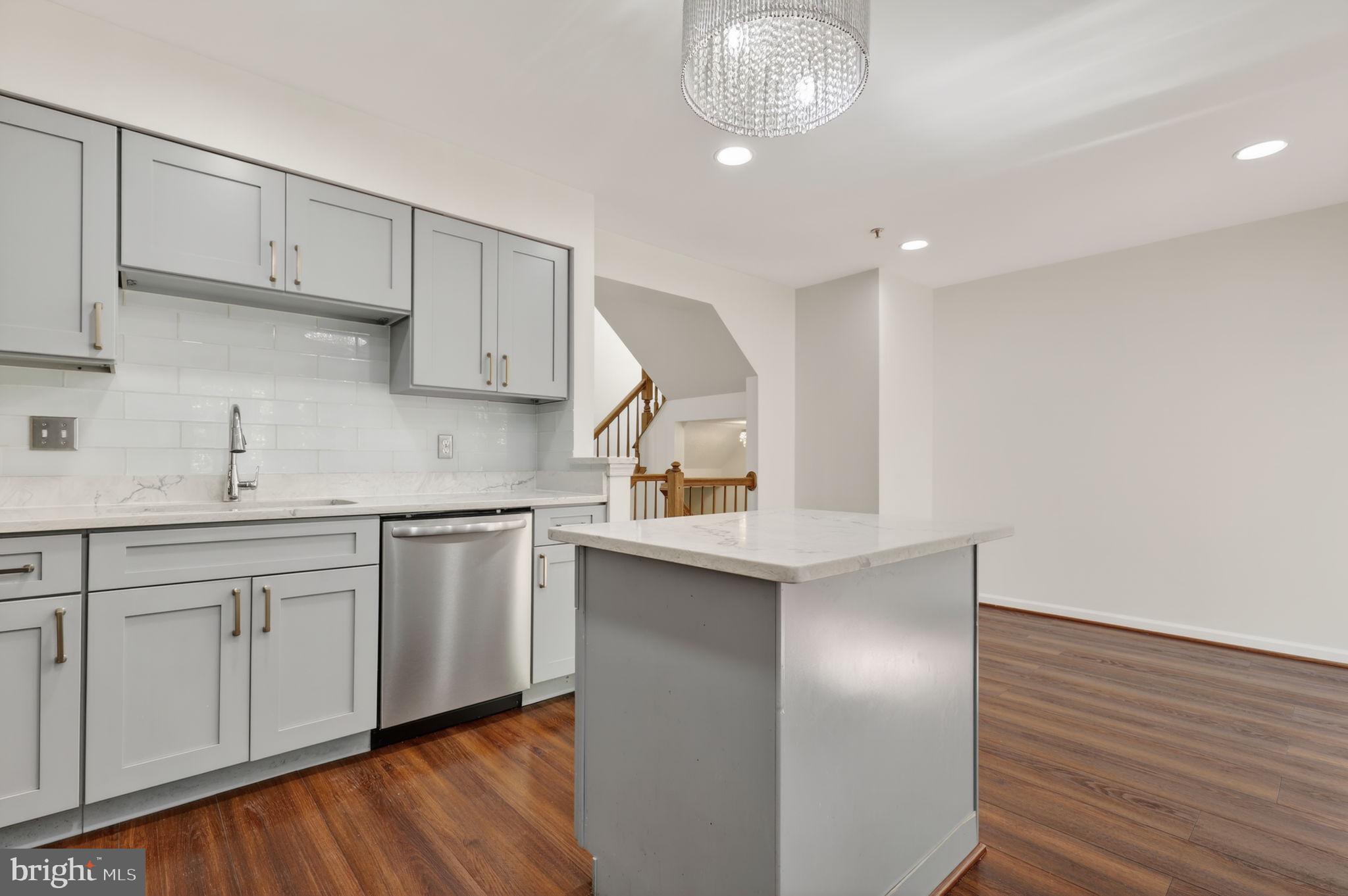 8612 Fire Rock Road Laurel, MD 20724 - Photo 16 of 57 a kitchen with stainless steel appliances granite countertop a sink cabinets and wooden floor