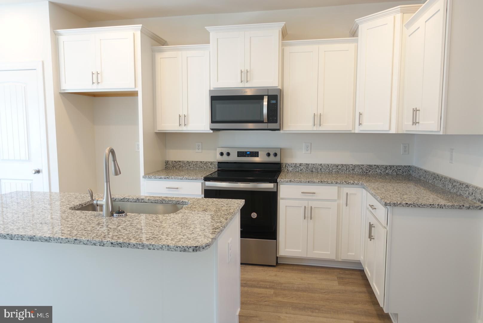 279 Ridgeview Lane, Unit 49 Hanover, PA 17331 - Photo 3 of 19 a kitchen with granite countertop a sink and a stove