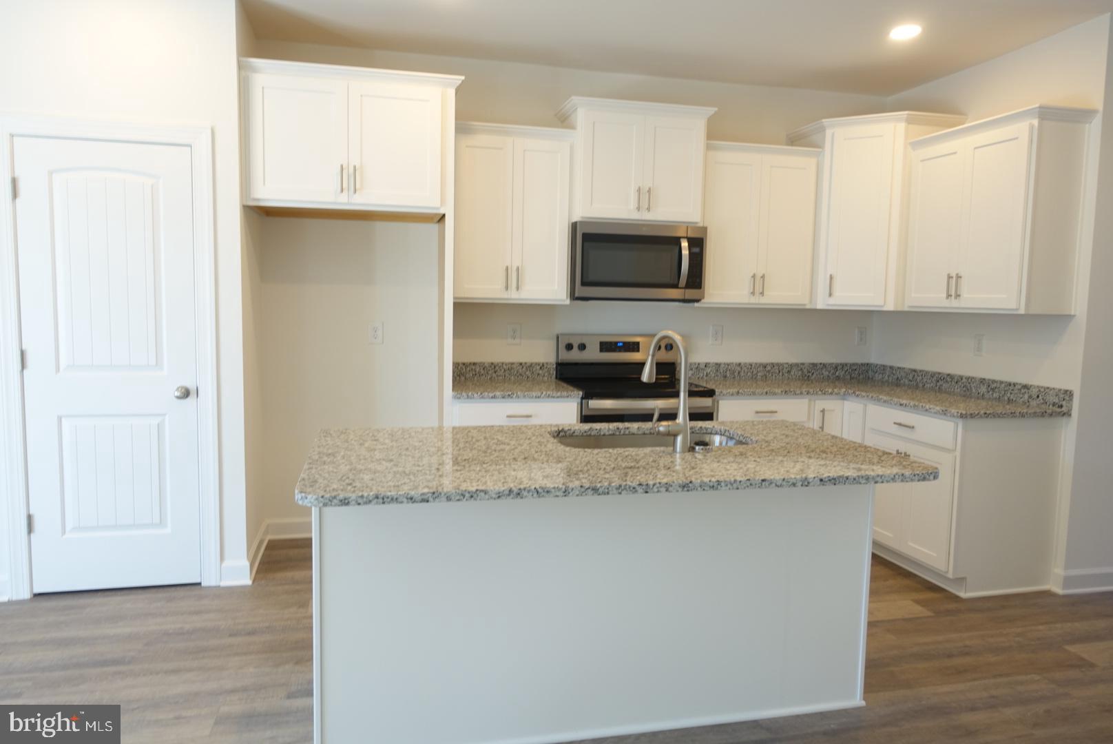 279 Ridgeview Lane, Unit 49 Hanover, PA 17331 - Photo 4 of 19 a kitchen with granite countertop a sink a stove top oven a counter space and cabinets