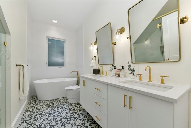 a bathroom with a double vanity sink mirror and toilet