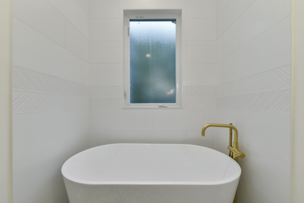 26 Bartlett Avenue Arlington, MA 02476 - Photo 14 of 27 a white bath tub sitting in a bathroom