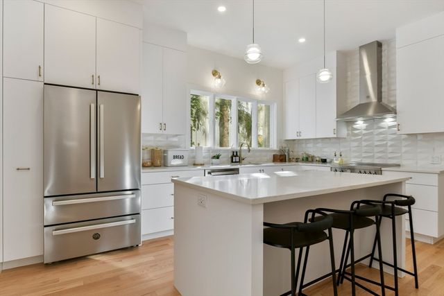 a kitchen with kitchen island a counter and a refrigerator
