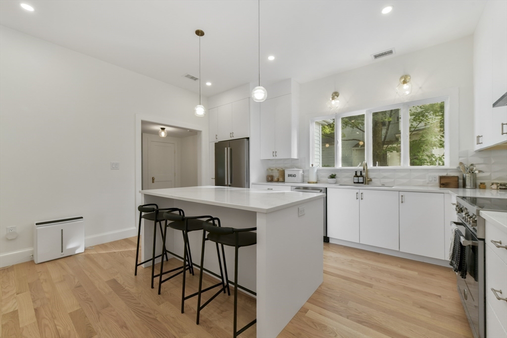 26 Bartlett Avenue Arlington, MA 02476 - Photo 17 of 27 a kitchen with a table chairs sink and cabinets