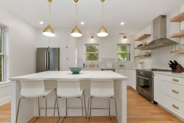 a kitchen with stainless steel appliances a table chairs sink and stove top oven